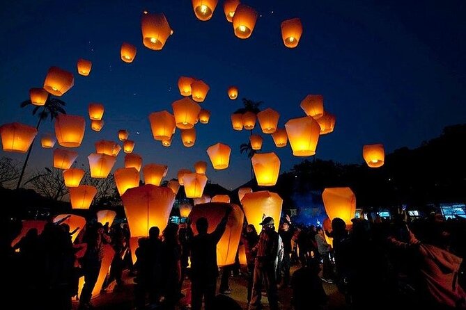 Sky lanterns rising over the railway at Shifen after dark